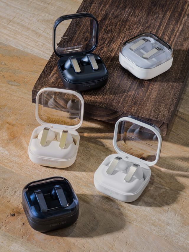 Estuches de Galaxy Buds4 Pro y Galaxy Buds4 en blanco, gris y negro sobre una mesa de madera