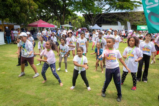 Niños bailan en la grama durante la actividad familiar