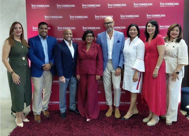 Equipo de Keller Williams República Dominicana y José Joaquín Alonso, de CLERHP, posan frente a un panel de KW Dominicana
