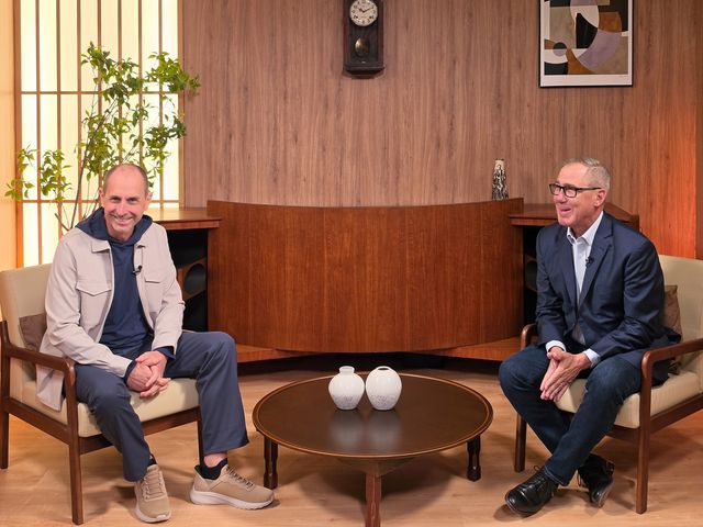 Armin Prommersberger y Dave Rogers, de HARMAN, sonríen sentados en un set de madera durante la entrevista