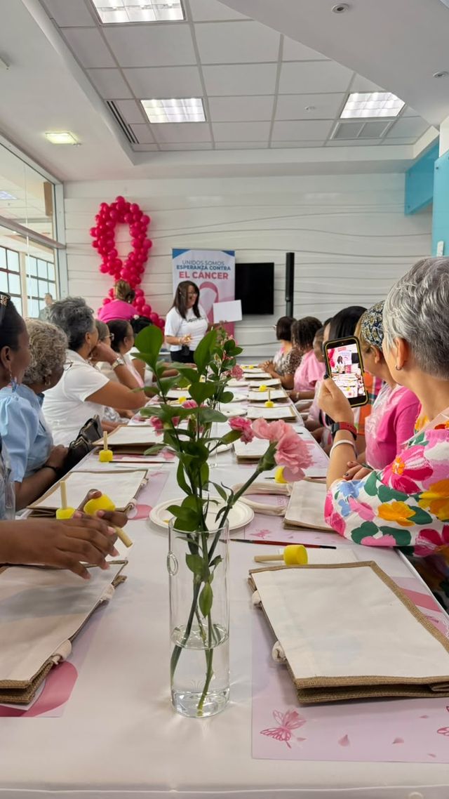 Participantes decoran bolsos en una mesa larga durante el taller de arteterapia