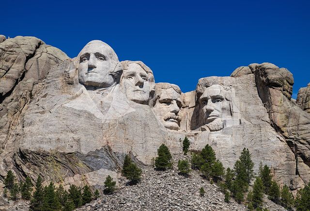 Las cabezas de Washington, Jefferson, Theodore Roosevelt y Lincoln talladas en el monte Rushmore bajo un cielo azul