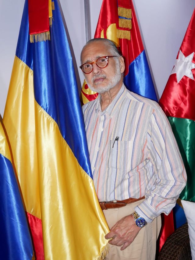 Arturo Villanueva Santiago, cónsul honorario de Rumanía, junto a la bandera rumana
