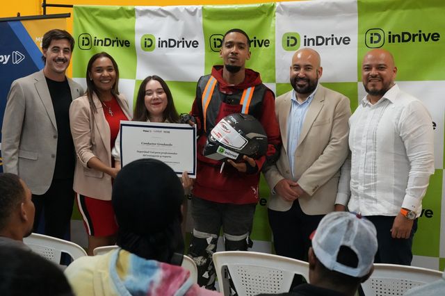 Representantes de Nippy, INTRANT e inDrive entregan un certificado y un casco a un conductor de motocicleta