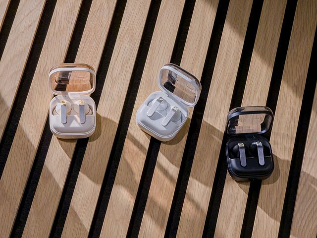 Tres estuches abiertos de Galaxy Buds4 Pro en distintos colores sobre listones de madera