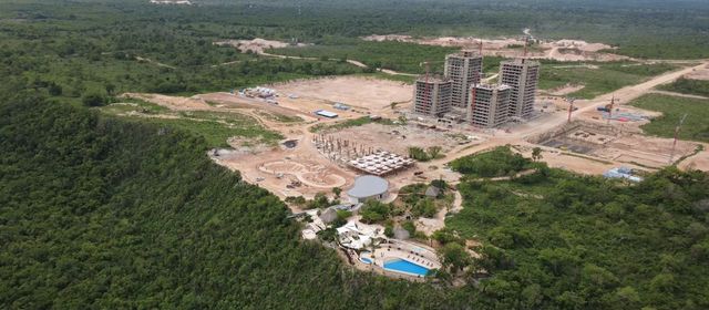 Torres residenciales en construcción rodeadas de vegetación en Larimar City & Resort