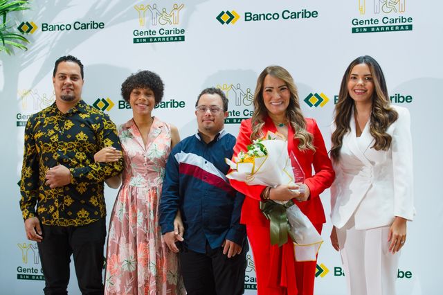 Wanda Camilo recibe un reconocimiento con flores en el foro Gente Caribe Sin Barreras de Banco Caribe