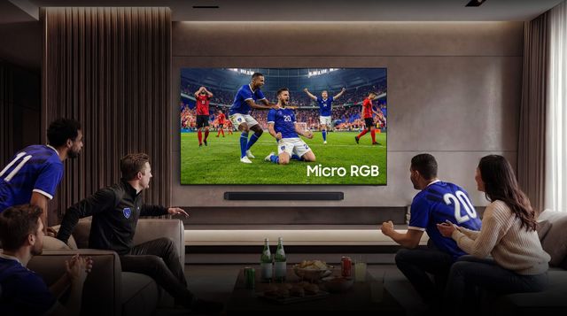 Un grupo de aficionados ve un partido de fútbol en un televisor Samsung Micro RGB de gran formato