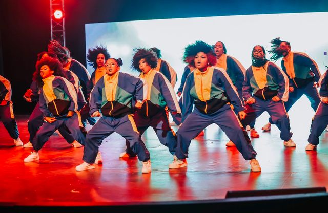 Estudiantes de Núcleo Extremo bailan en el show Urban Monster con chaquetas azules