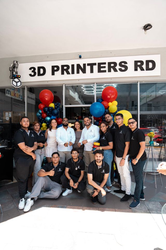 Equipo de 3D Printers RD frente al letrero de la nueva sucursal