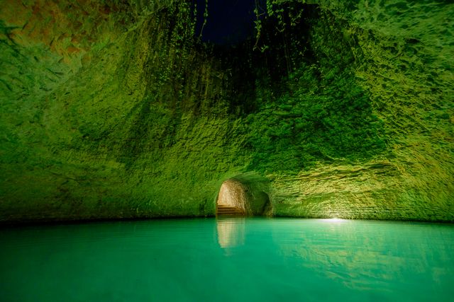 El cenote iluminado desde el fondo con aguas color turquesa
