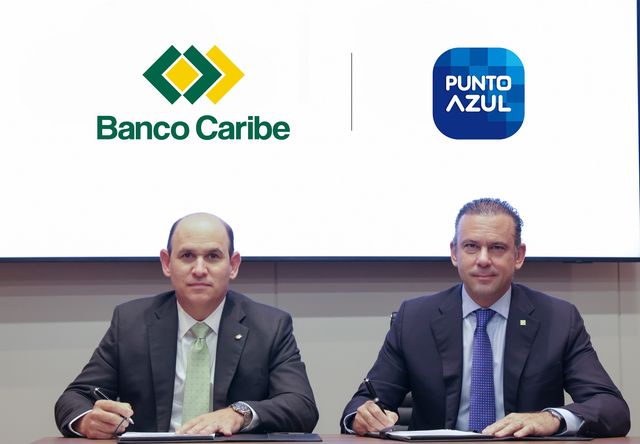 Edgar Del Toro y Eugene Rault Grullón firman el acuerdo frente a los logos de Banco Caribe y Punto Azul