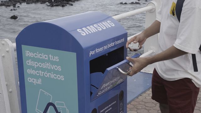 Una persona deposita un dispositivo en un contenedor de reciclaje electrónico de Samsung