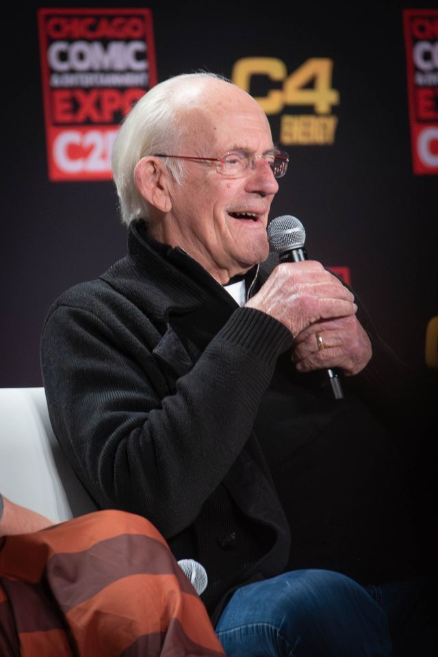 Christopher Lloyd sonríe con un micrófono en la mano durante un panel de la convención C2E2 de Chicago en abril de 2024