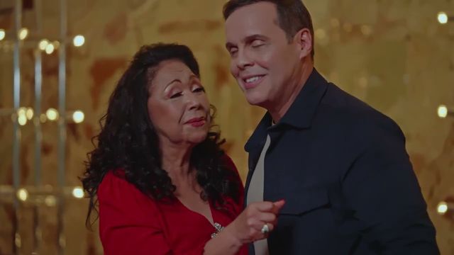 Adalgisa Pantaleón, de vestido rojo, y Frank Ceara cantan juntos en una escena del video de «La receta perfecta»