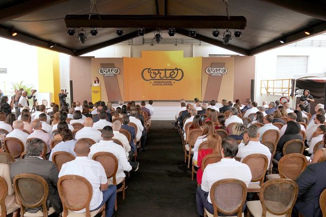 Invitados sentados en el salón de la inauguración, decorado con los colores de Cortés