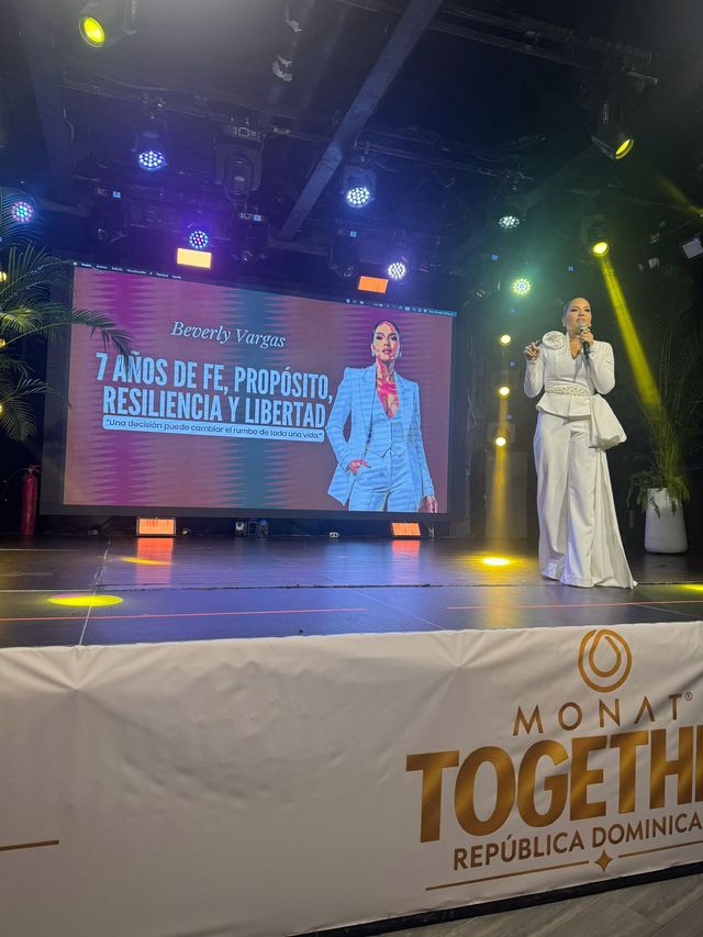 Beverly Vargas en la tarima frente a una pantalla con su conferencia