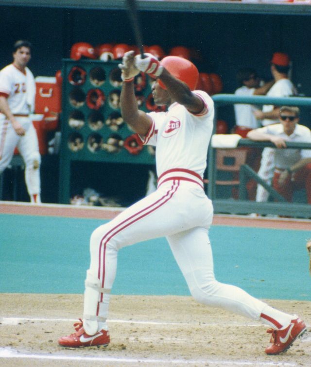 Mariano Duncan batea con el uniforme blanco de los Rojos de Cincinnati en el Riverfront Stadium en 1990