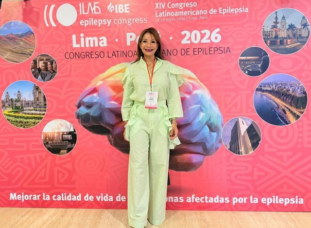 La doctora Sorivel Álvarez frente al mural del XIV Congreso Latinoamericano de Epilepsia en Lima