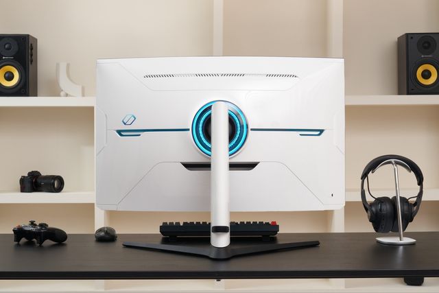 Monitor Samsung Odyssey blanco sobre un escritorio gamer con bocinas y audífonos
