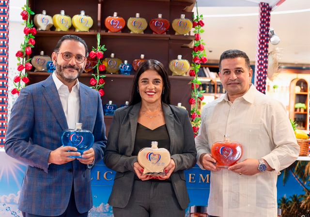 Carlos Núñez, Delvair Amarilla y Julio Astacio con botellas de I LOVE D.R. en el Aeropuerto Internacional de Las Américas