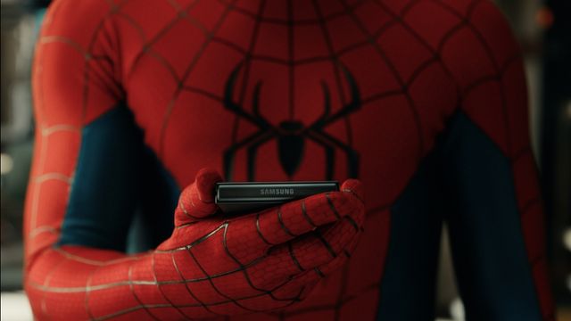 Spider-Man sostiene un teléfono Samsung en la mano