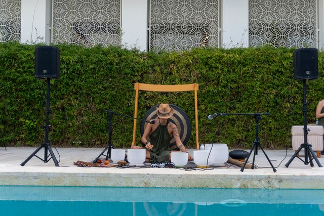 Un músico toca cuencos y un gong junto a la piscina de YHI Spa