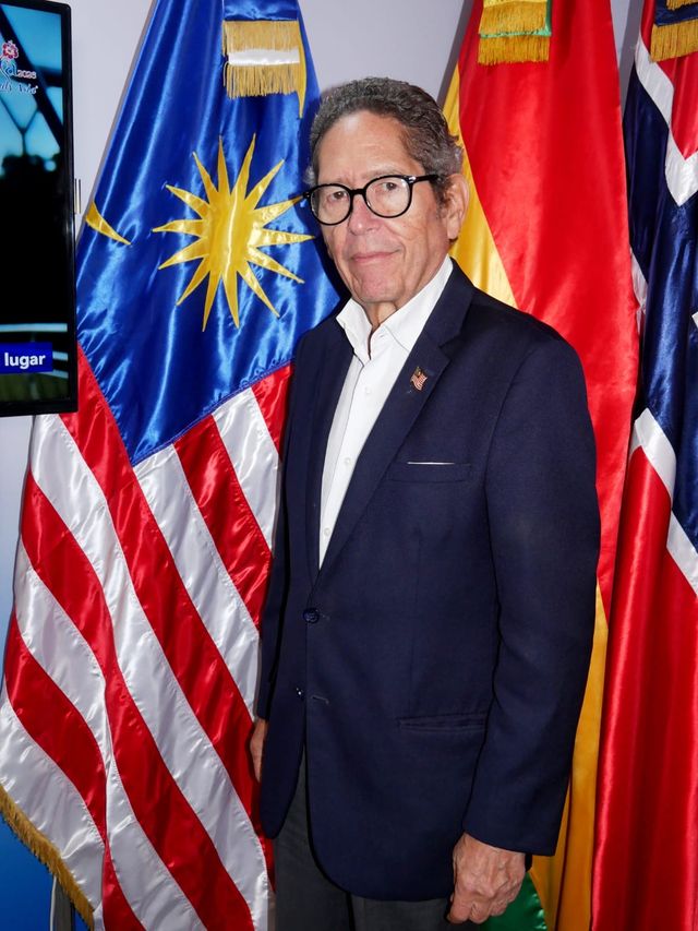 Fernando González Nicolás, cónsul honorario de Malasia, junto a la bandera malasia