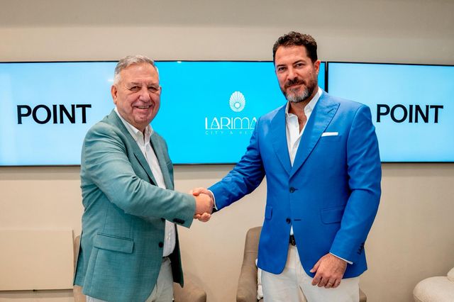 Vicente Pons y Juan Andrés Romero se dan la mano frente a pantallas con los logos de Point y Larimar