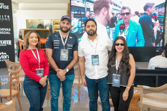 Mercilina Reyes, Bryant Tejeda, Cristofer Jiménez y Leslie Ramírez frente a una pantalla con la carrera de Fórmula 1