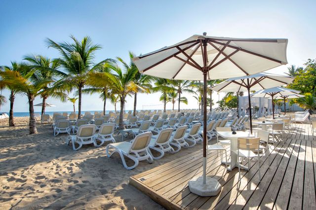 Terraza con sombrillas y tumbonas frente al mar en Viva Heavens
