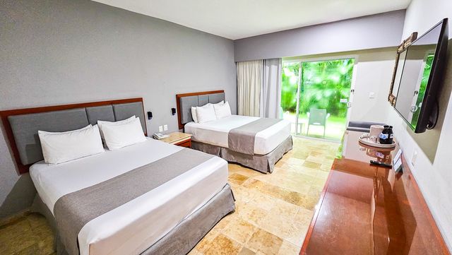 Habitación con dos camas y balcón en Viva Heavens by Wyndham