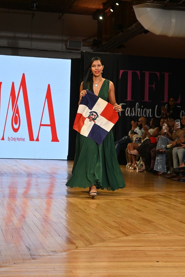 La diseñadora Cindy Martínez en la pasarela con la bandera dominicana