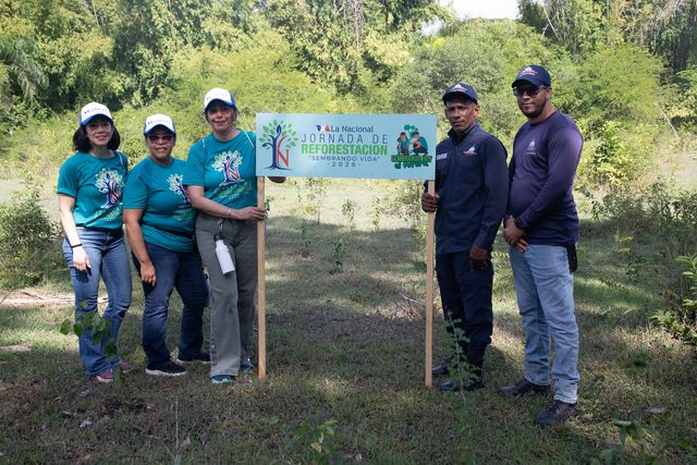 Participantes junto al letrero de la jornada de reforestación de La Nacional