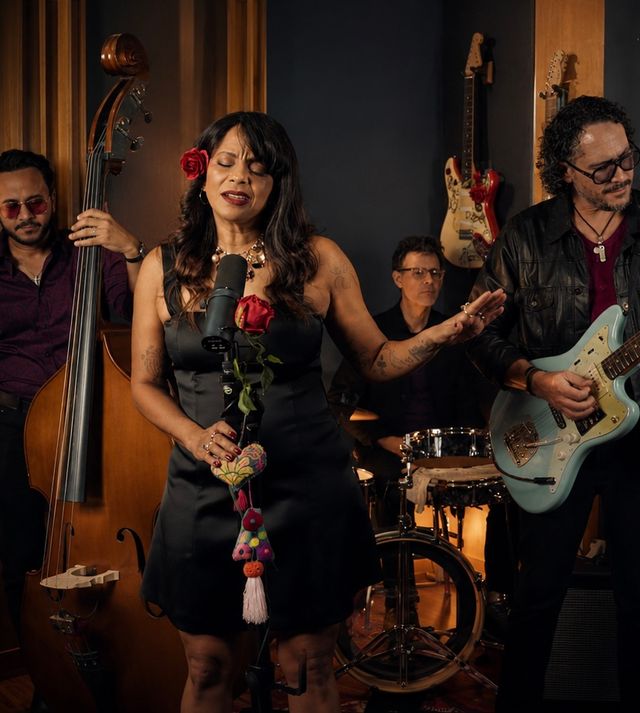 La vocalista de MarteOvenus canta con una rosa roja en la mano, acompañada por la banda
