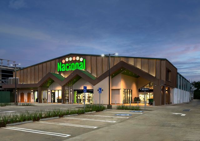 Fachada de Supermercados Nacional Jarabacoa iluminada al anochecer