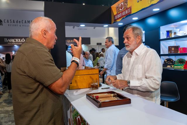 Dos asistentes conversan frente a un stand de cigarros en el festival