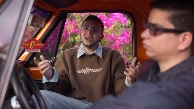 Los dos integrantes de Martox conversan dentro de una camioneta naranja en el video de «De Cero»