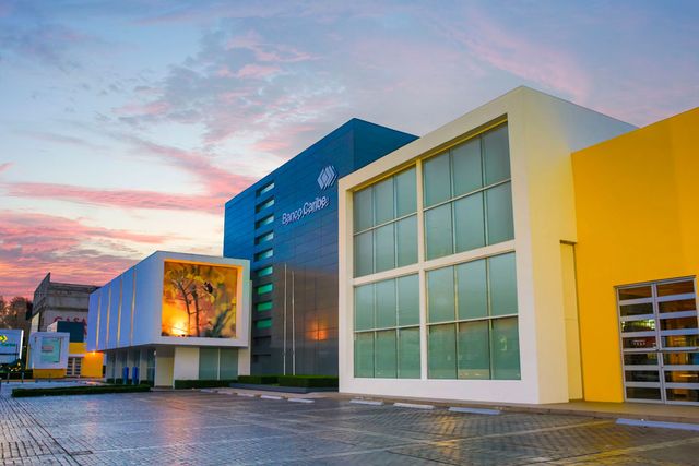 Fachada de la sede central de Banco Caribe en El Vergel, Santo Domingo, al atardecer