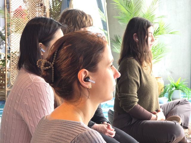 Una mujer usa los Galaxy Buds4 durante una sesión de relajación en grupo