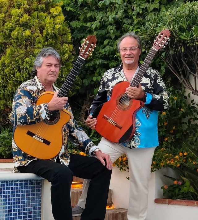Los Gypsies con sus guitarras junto a un jardín
