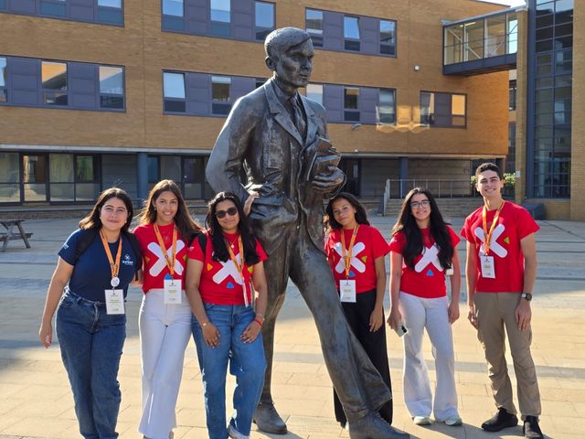 La delegación dominicana de XPERTSTEM, con camisetas rojas, posa junto a una estatua en Reino Unido